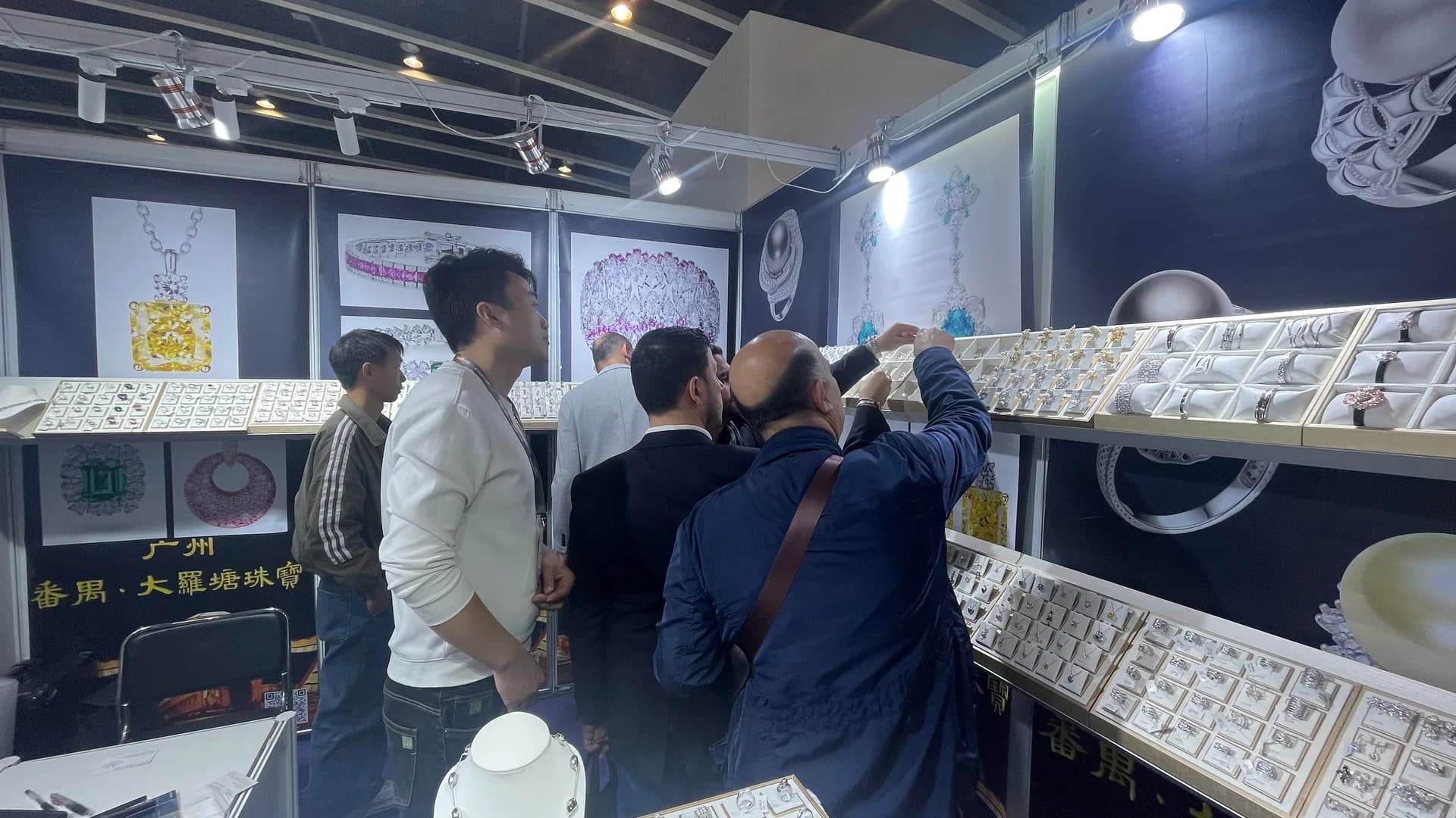 Buyers reviewing jewelry with the Zalson team at a Hong Kong exhibition booth