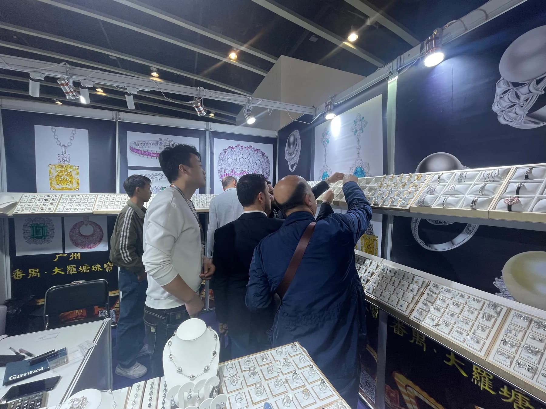 Trade buyers examining jewelry at the Zalson Jewelry exhibition booth in Hong Kong